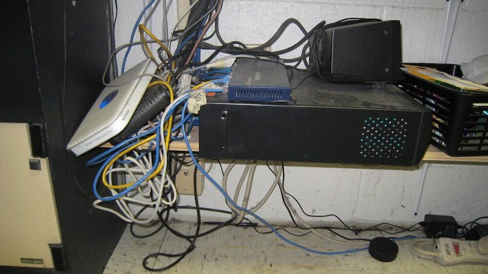 Before photo of messy network cables and equipment before professional cable management